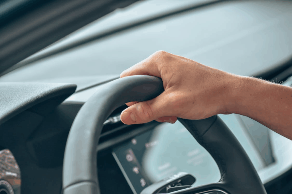 close-up of a person's hand on a steering wheel