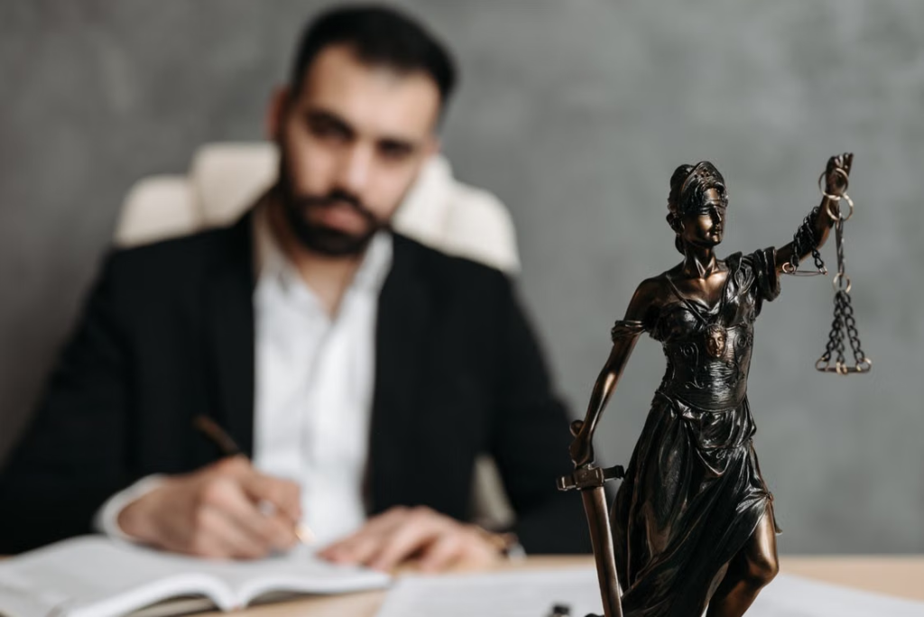 A lawyer sitting with a Lady Justice statue on his desk