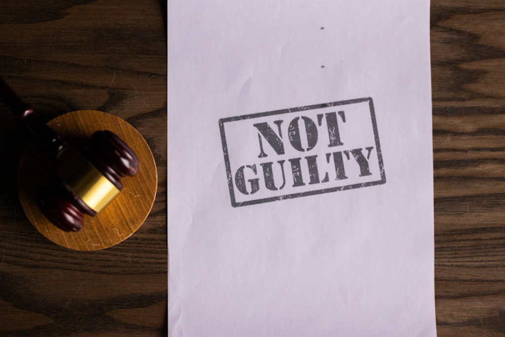 A paper next to a gavel with the words “not guilty” written on it