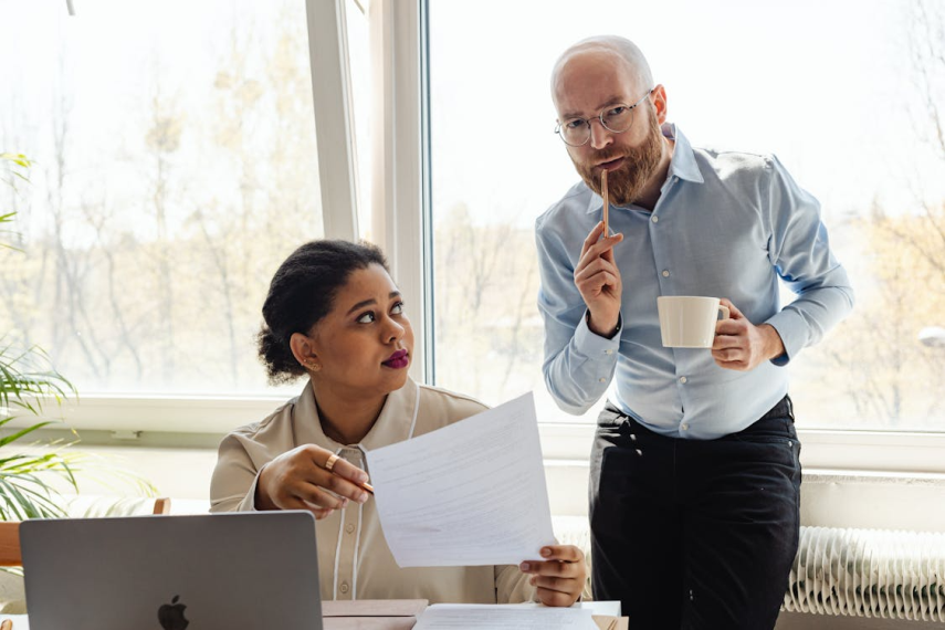 An image of a man and a woman looking at a paper