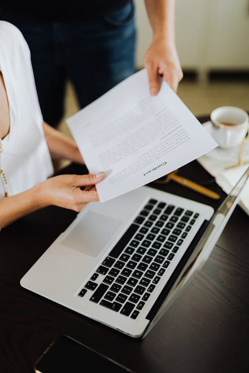 An image of a person handing over a document to another person