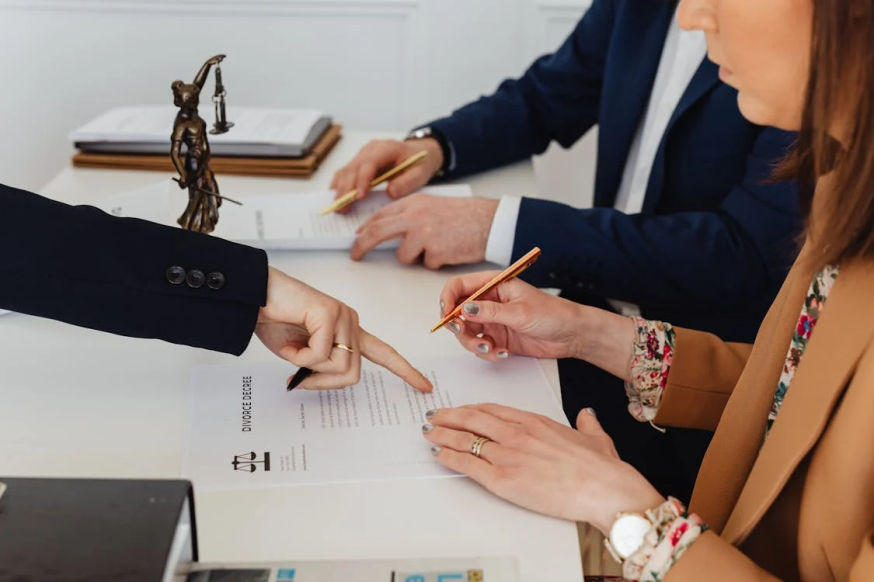 An image of a person holding a pen to sign on a paper