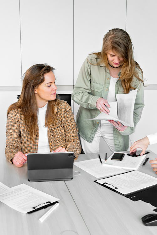 An image of people discussing while looking at some files