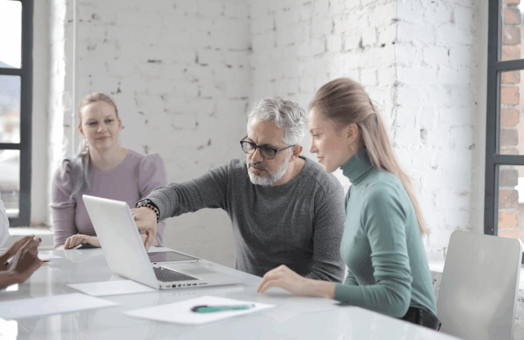 An image of people looking at a laptop