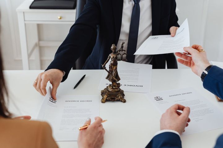 An image of people exchanging legal documents over a table