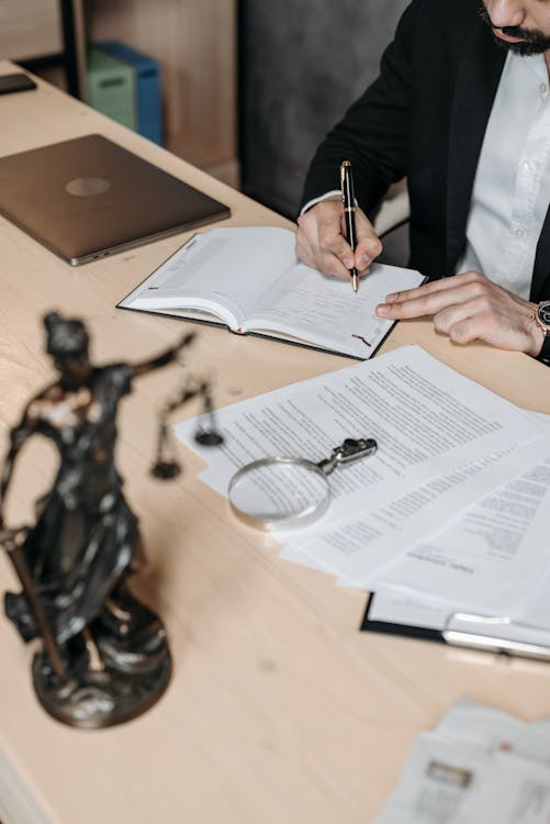 Man writing notes in a notebook, preparing for a DUI defence strategy meeting.