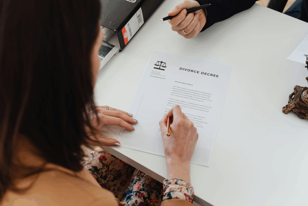 Woman signing legal documents with a pen, symbolizing agreements on child and spousal support