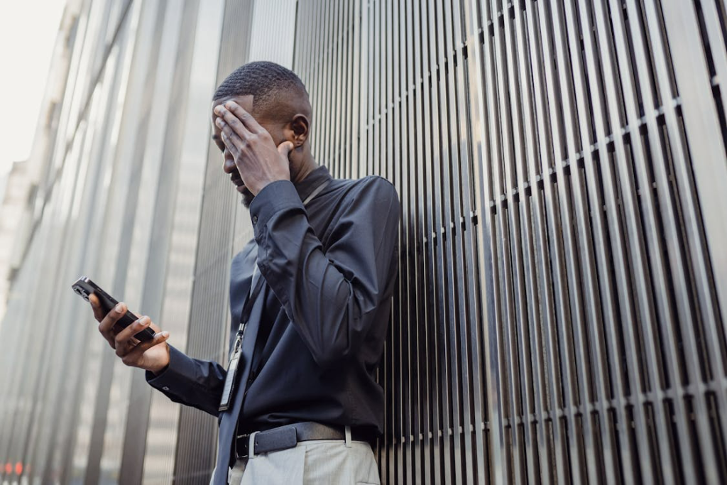 Young professional checking smartphone with concerned expression, representing reputational anxiety during legal proceedings