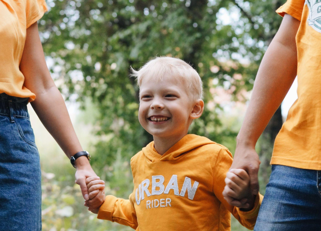a child holding their parents’ hands
