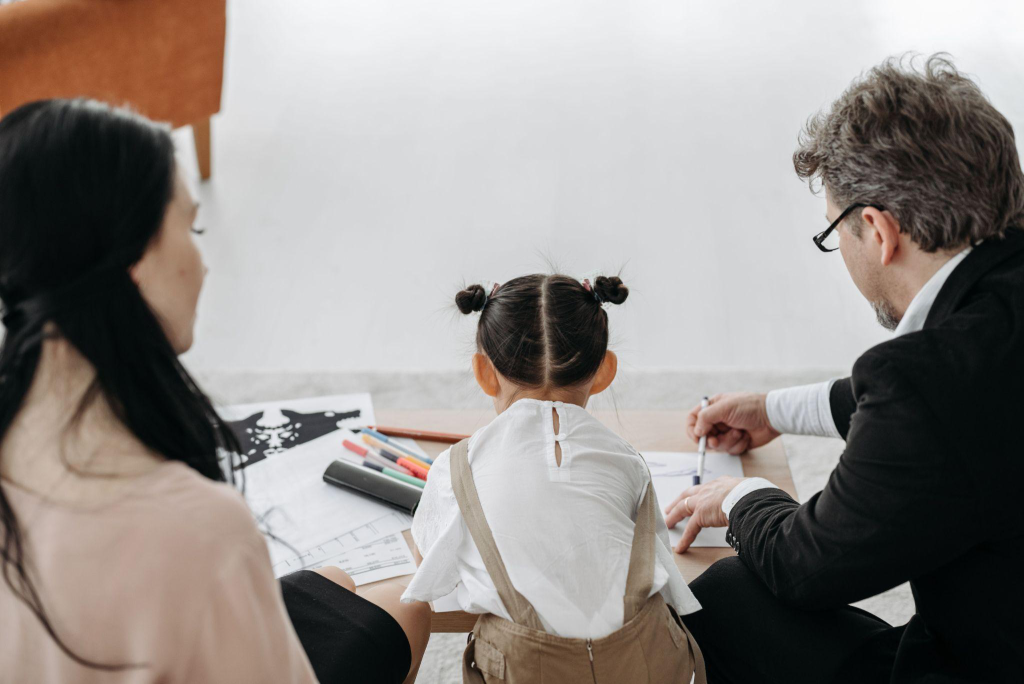 a divorced couple sitting with their child