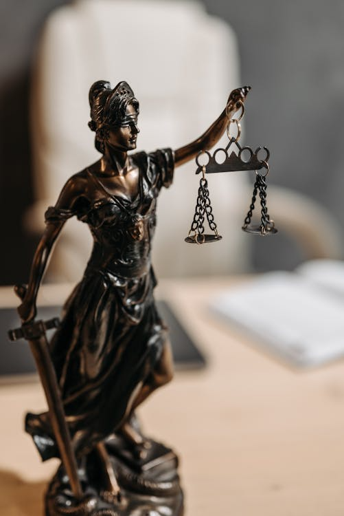 a figurine of Lady Justice on a lawyer's table