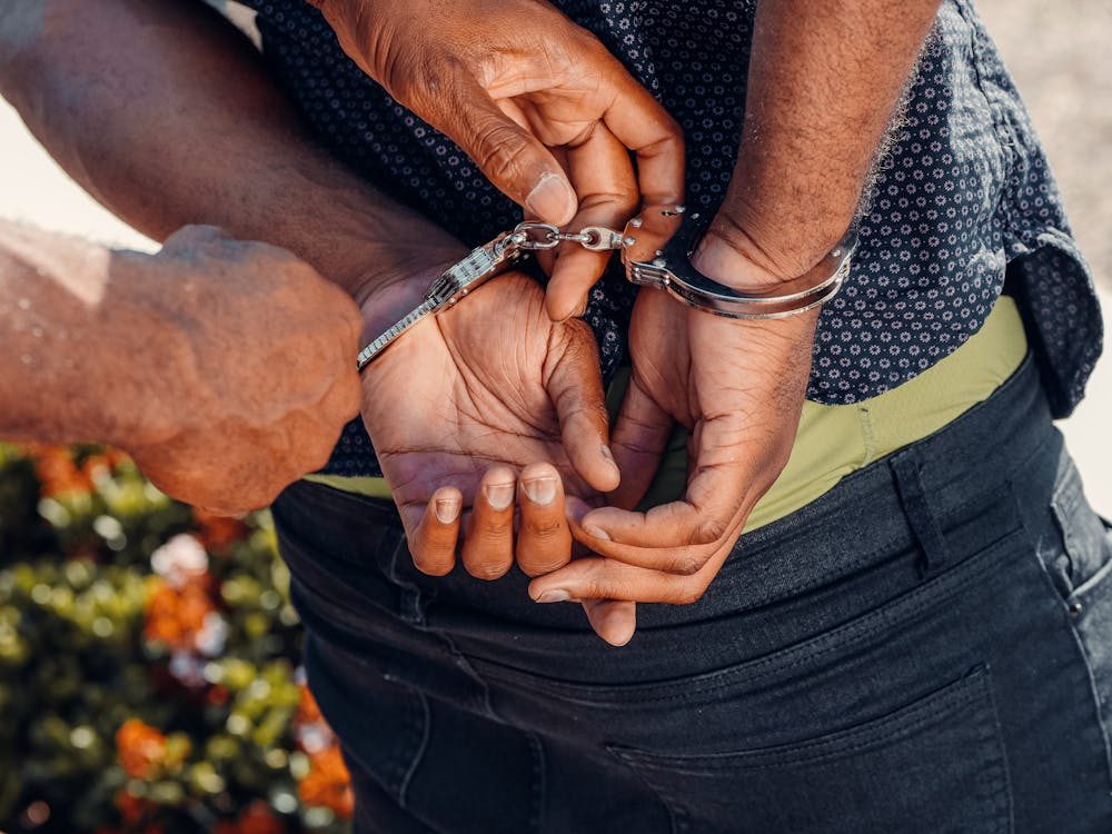 a person getting arrested with handcuffs