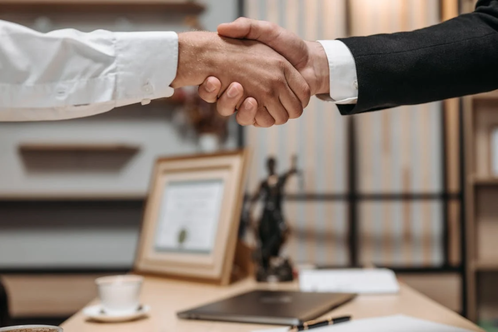 close-up of a client and a lawyer shaking hands at the lawyer’s office