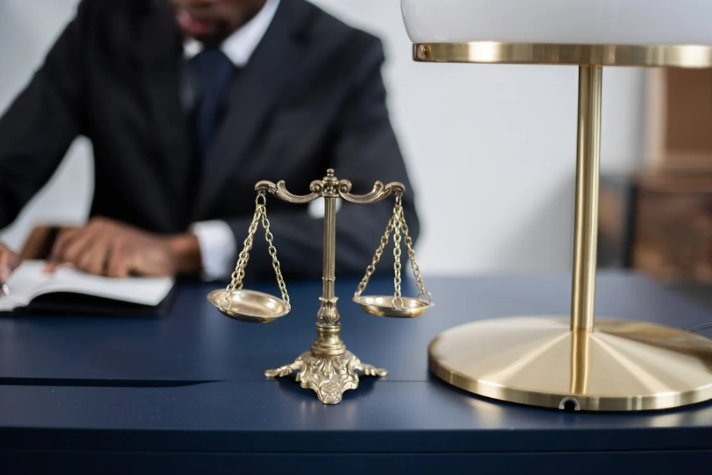 close-up of a lawyer’s desk with a balance scale placed next to a lamp at the front