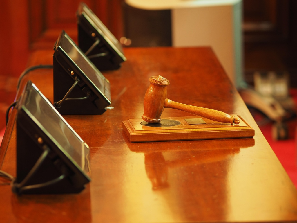 the judges' gavel placed on a wooden desk in the court